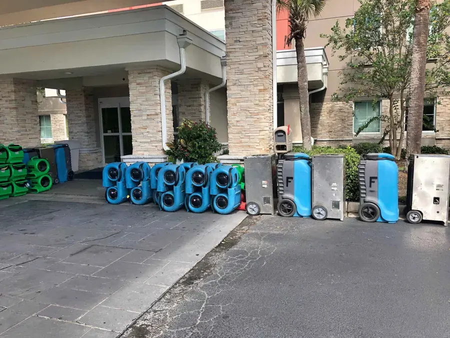 Air movers and dehumidifiers staged outside a building before a commercial dry-out