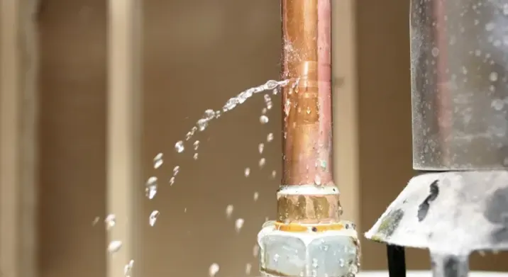 Copper supply pipe spraying water from a split fitting