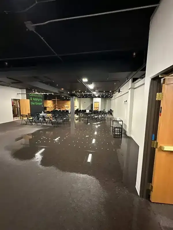 Standing water across the floor of a commercial hall and corridor